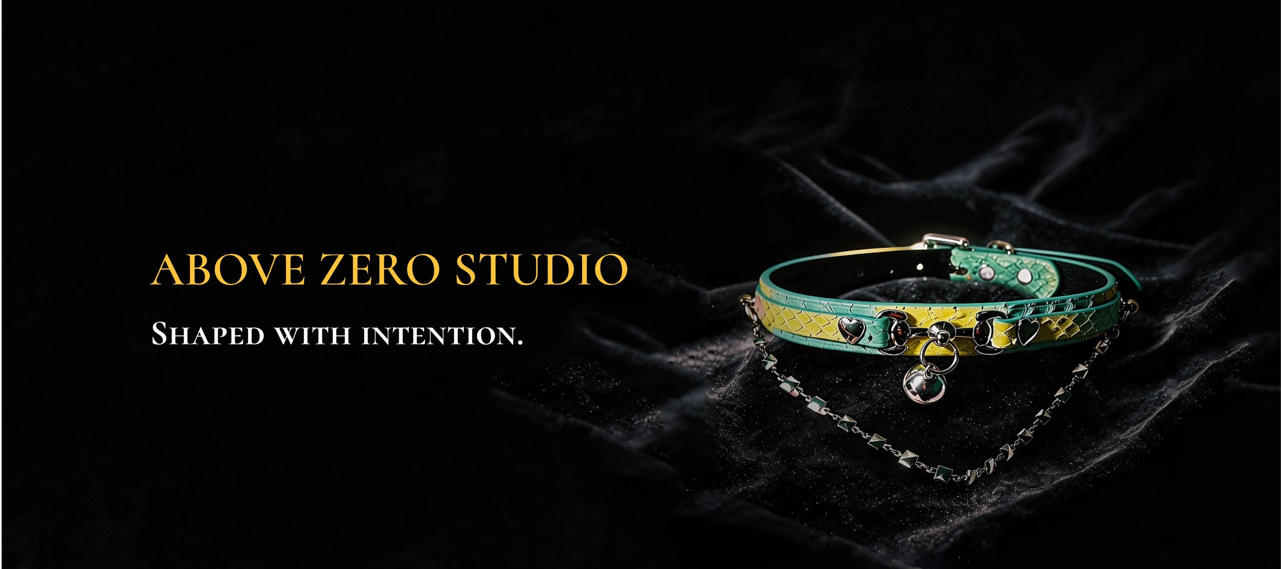 Above Zero Studio desktop banner with green heart chain collar on black satin