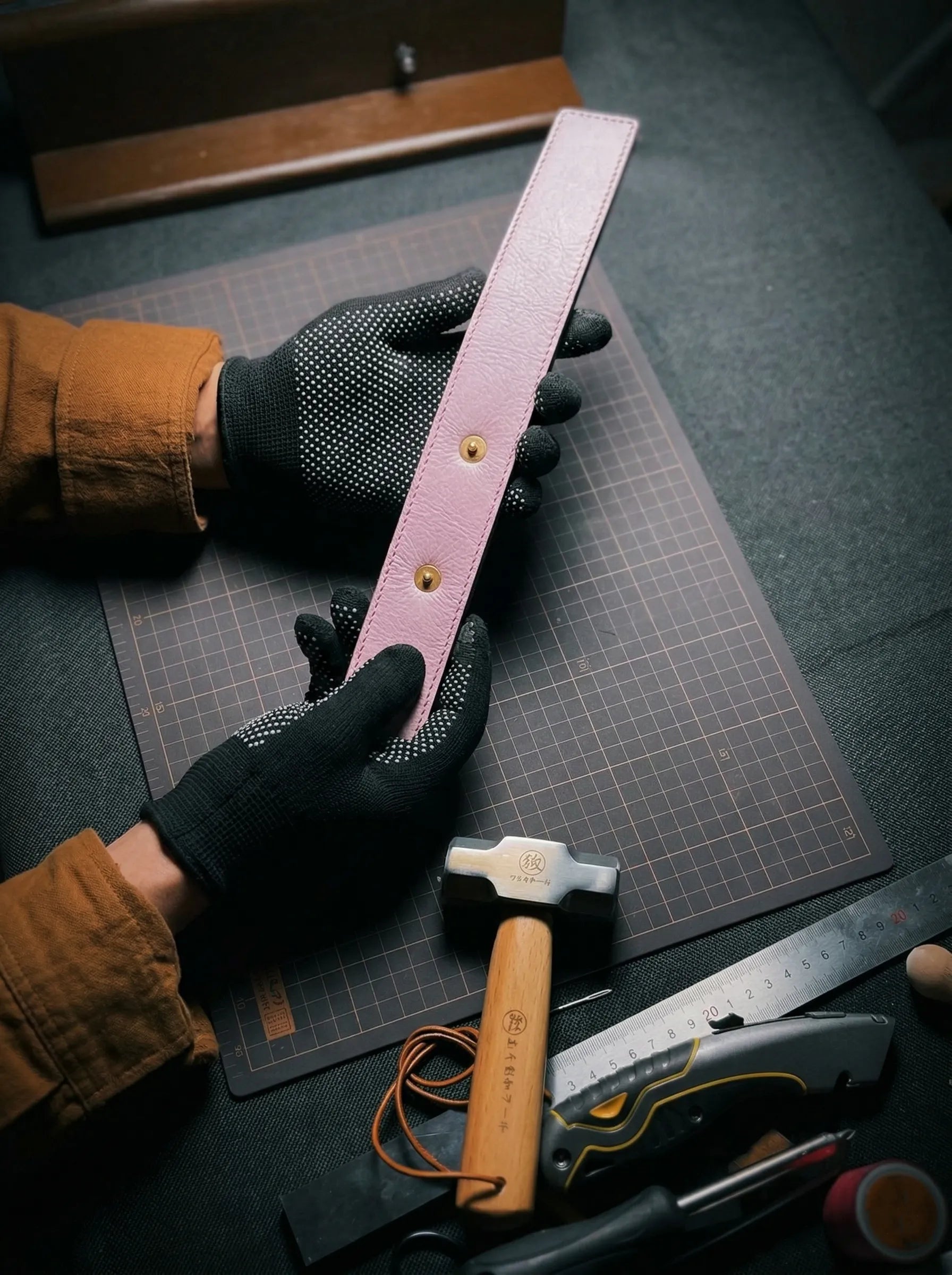 Above Zero Studio handmade leather piece being shaped on a workshop cutting mat
