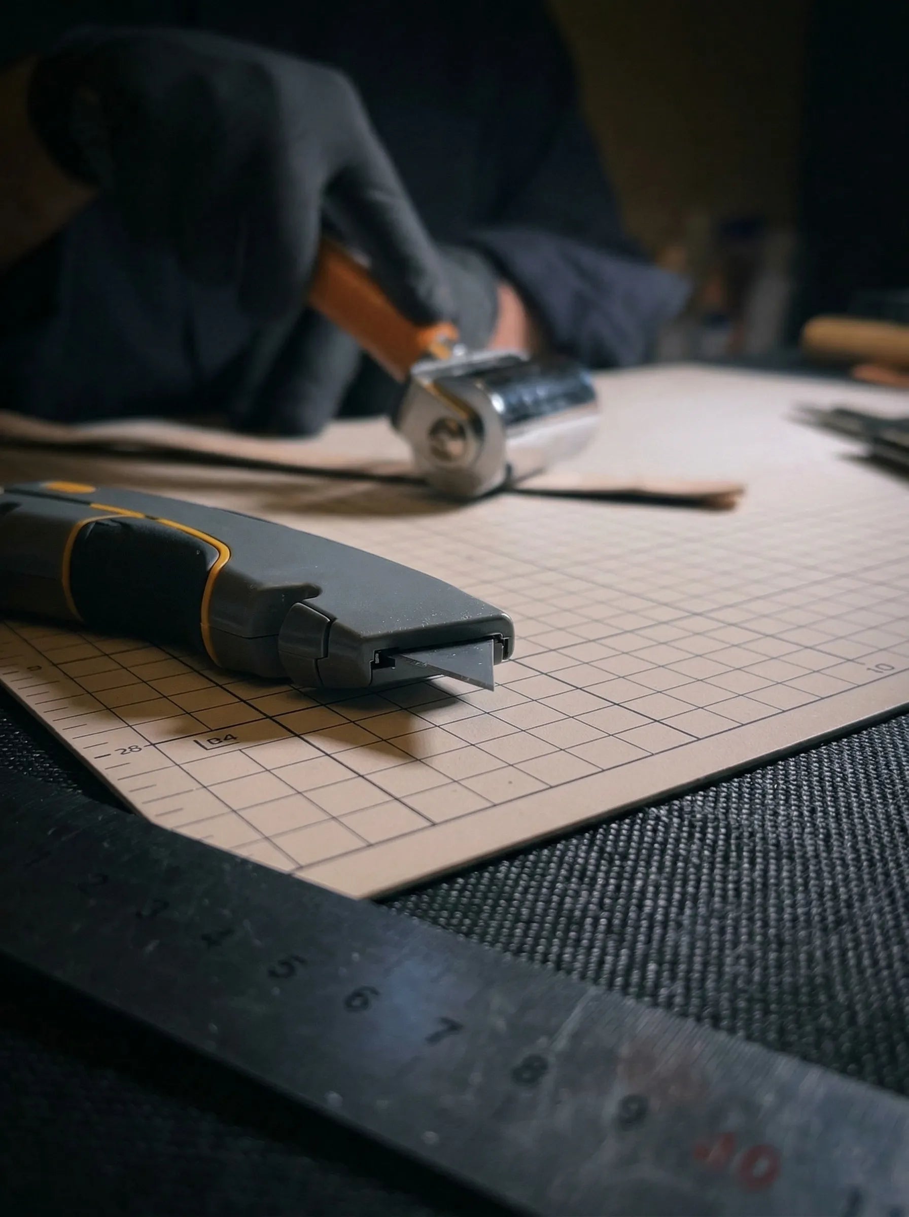 Above Zero Studio leather making tools detail with ruler, pencil, and cutting mat