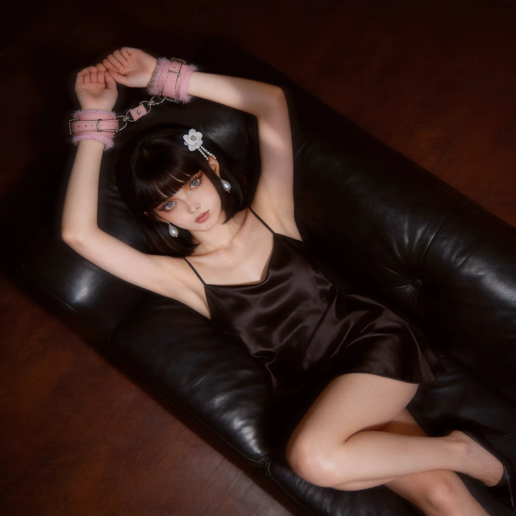 Blush Bond leather wrist cuffs model-worn scene on a reclining model against a black leather chair with plush lining and blush leather finish