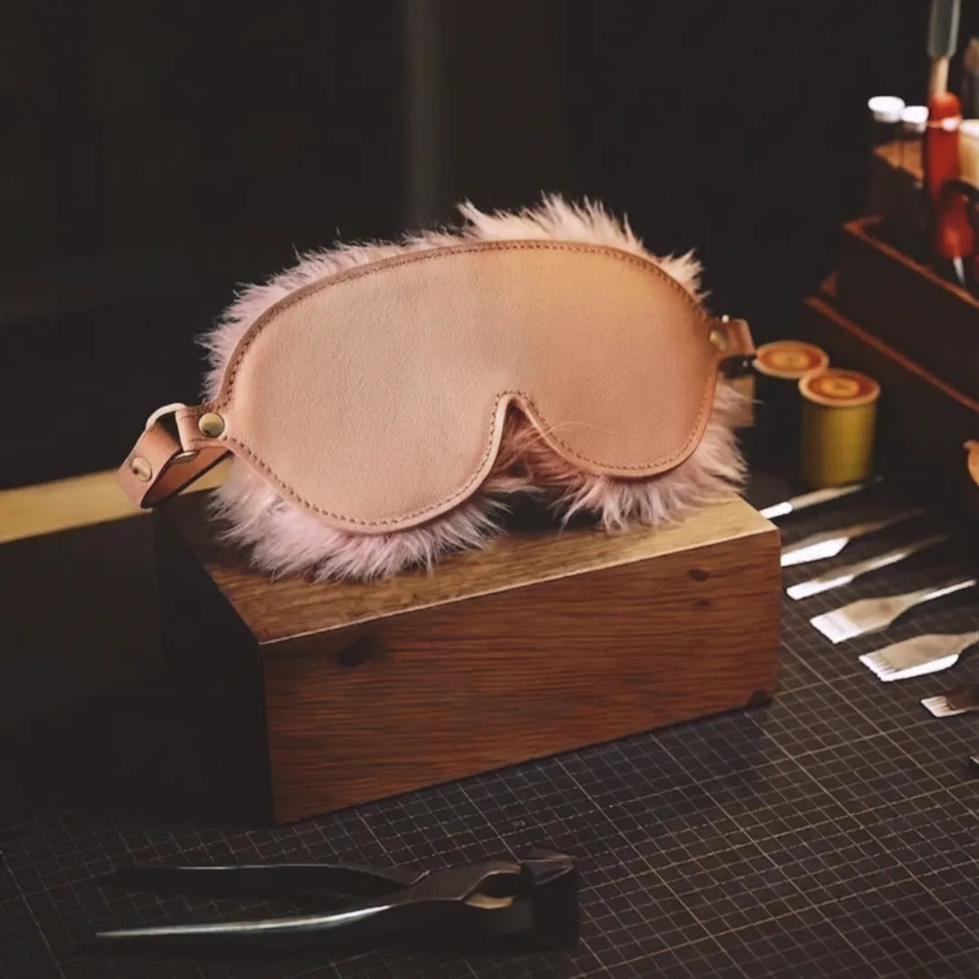 Blush Veil leather blindfold studio workbench scene with blush leather exterior and faux-fur edge