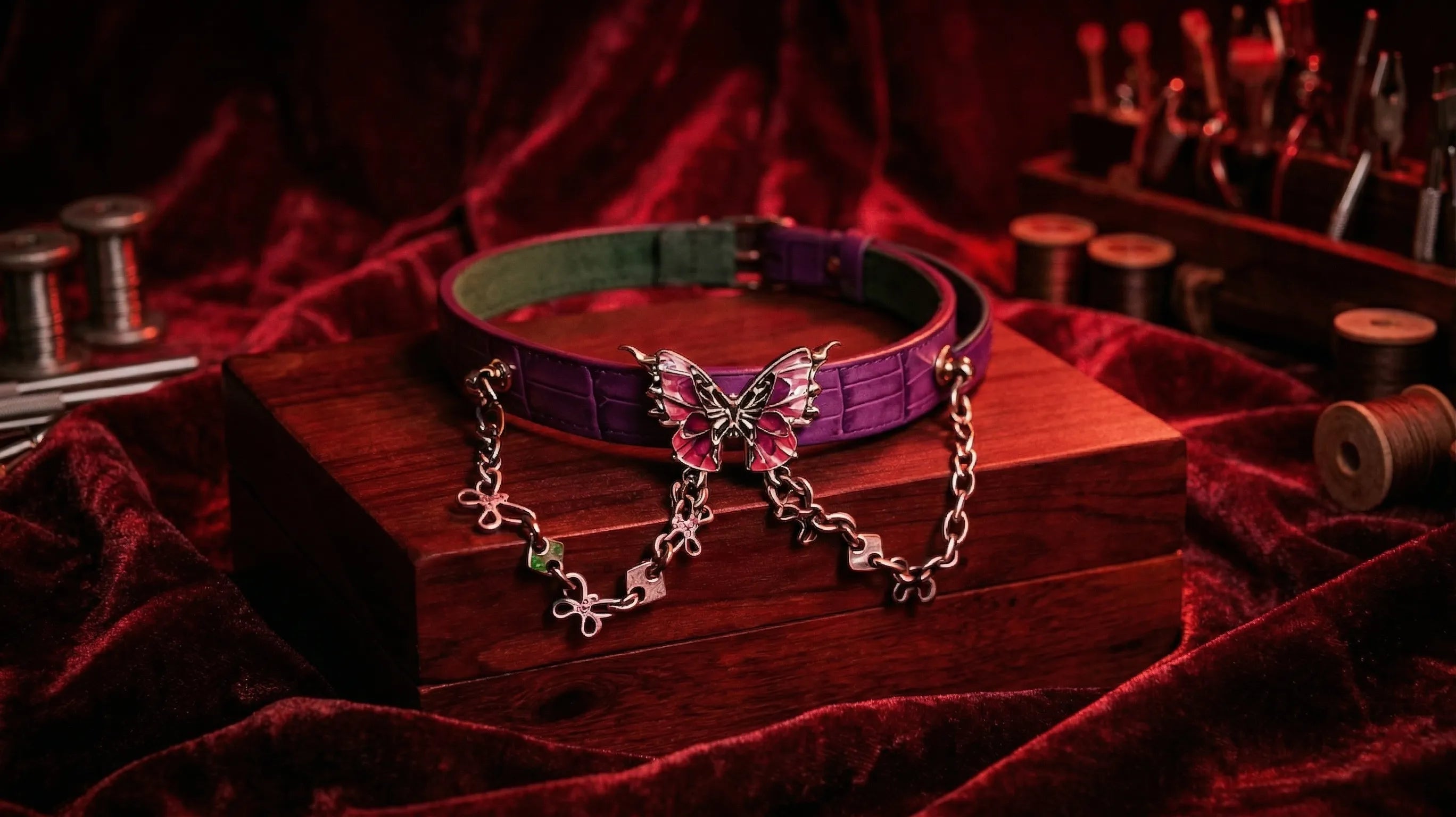 Leather collar collection display on red velvet fabric with chain and buckle details