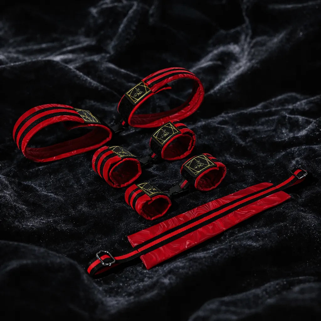 Crimson Order 7-piece restraint set front view with padded cuffs, red finish, and black webbing