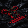 Crimson Order 7-piece restraint set front view with padded cuffs, red finish, and black webbing