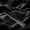 Noir Grid Patent Texture Leather Paddle black patent leather paddle on black satin with grid texture.