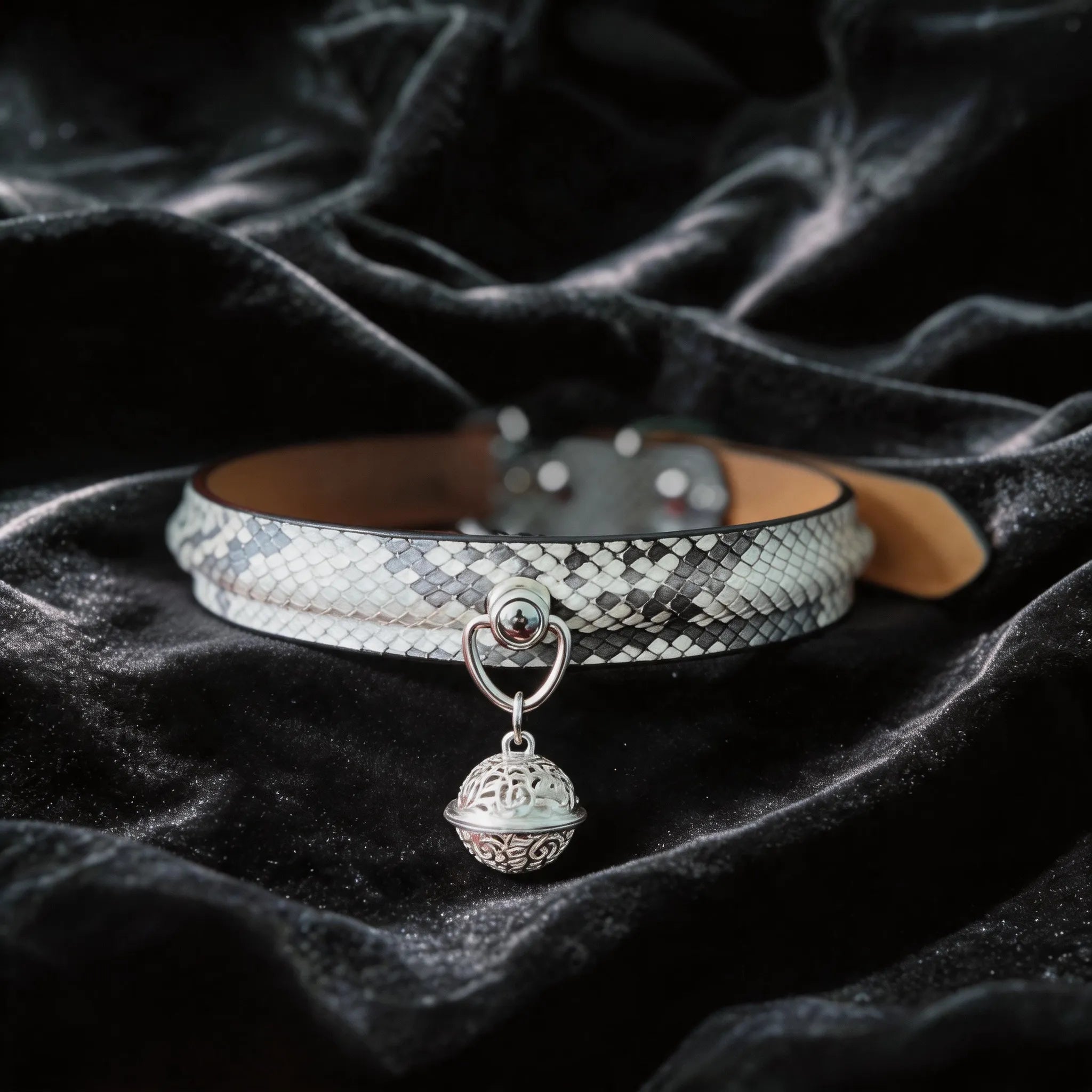 Python Echo Bell Leather Collar white and black python-textured leather collar on black satin with bell charm.