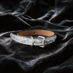 Python Echo Bell Leather Collar hand-held studio detail showing bell charm and silver hardware.