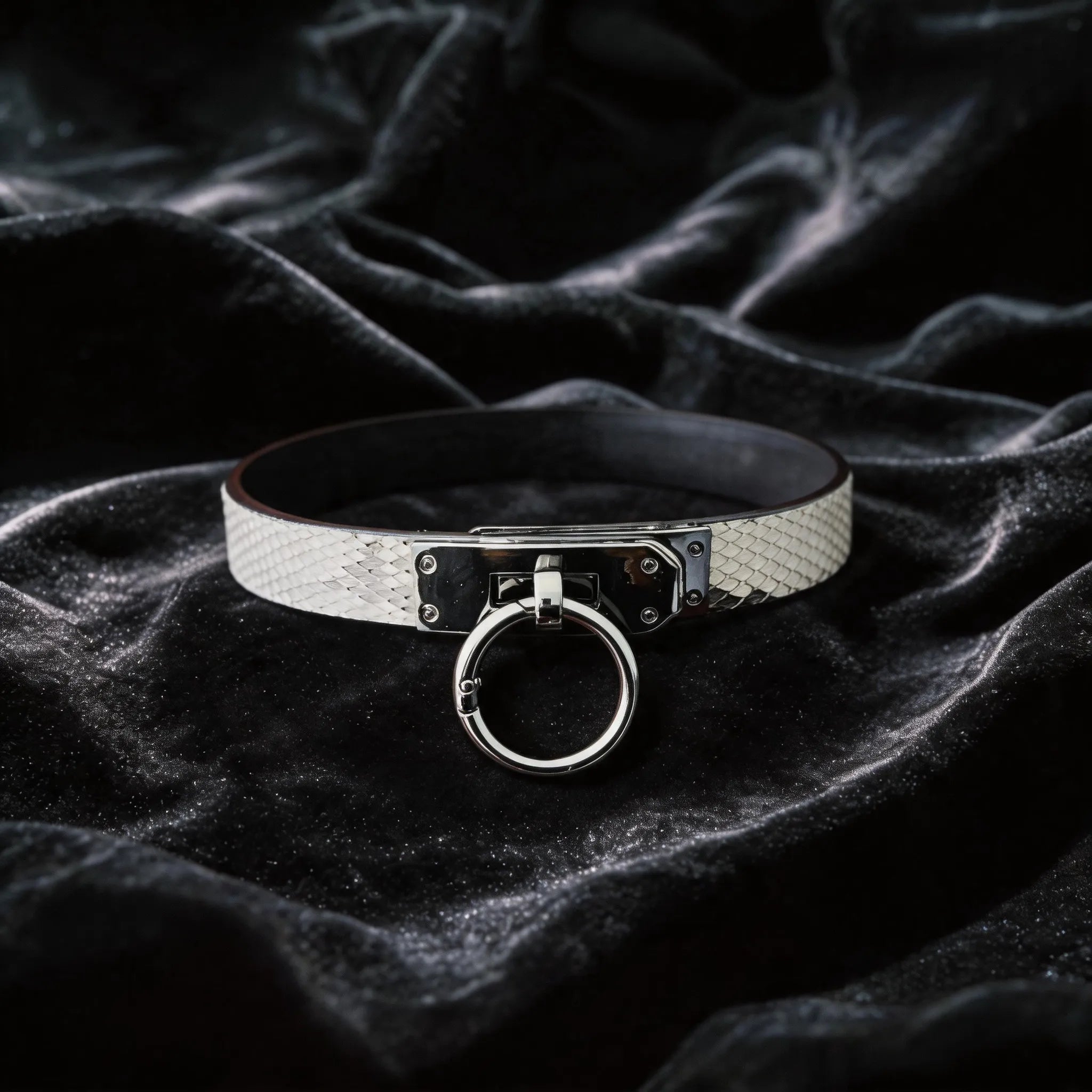 Python Lock O-Ring Leather Collar white and black python-textured leather collar on black satin with O-ring front.