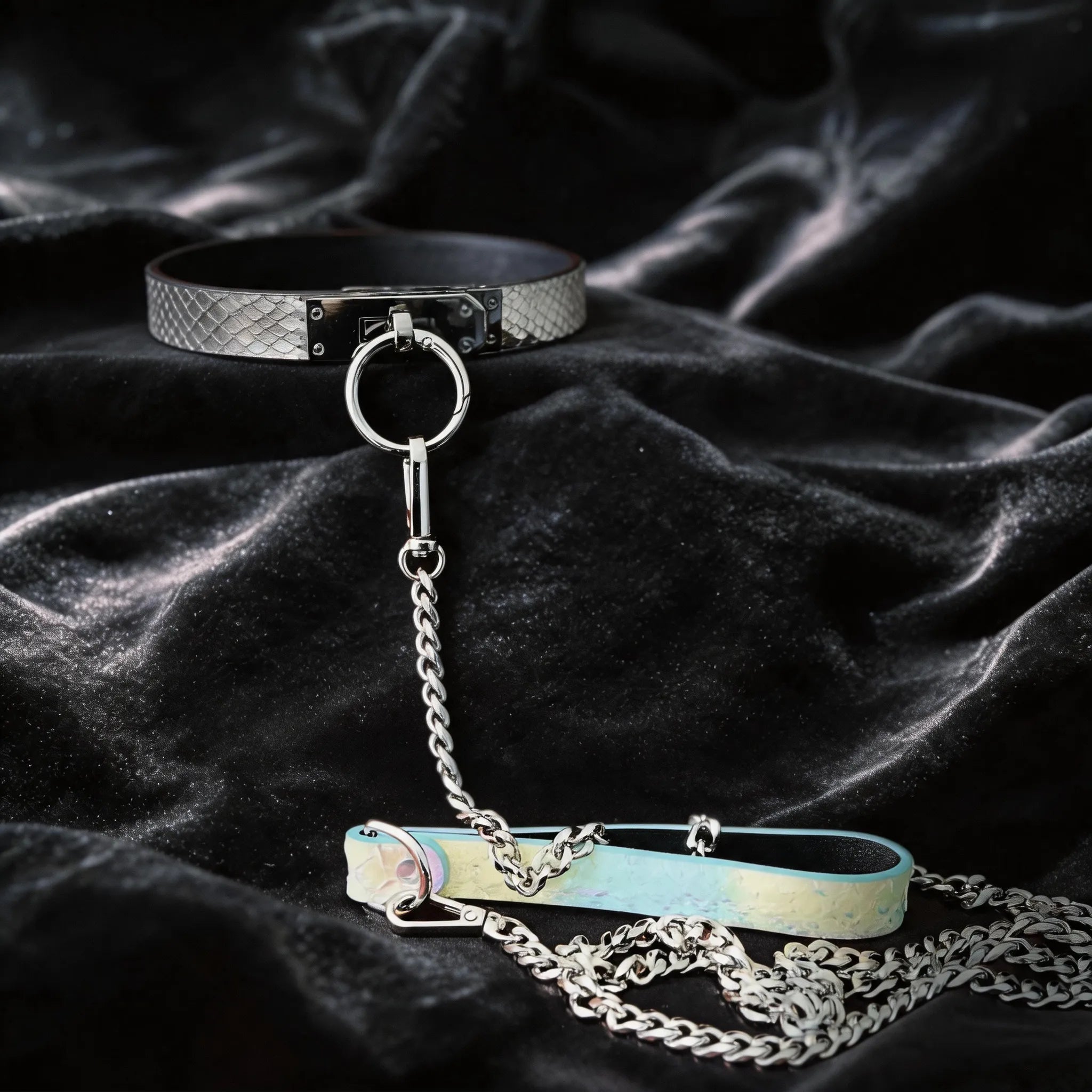 Python Lock O-Ring Leather Collar hand-held studio detail showing O-ring front and silver chain hardware.