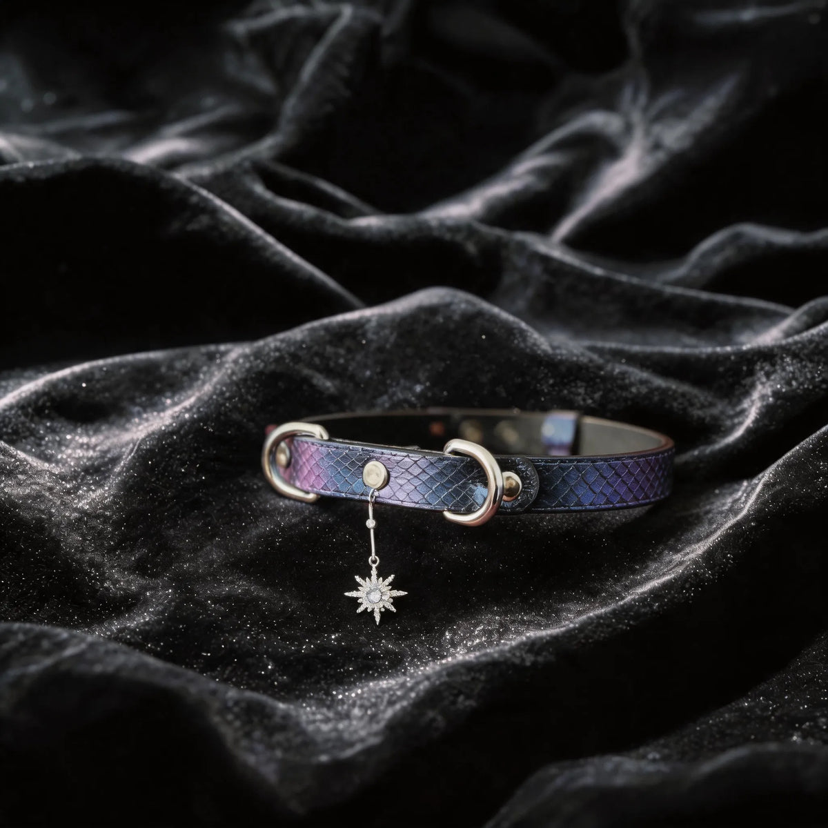 Python Star Pendant Leather Collar angled on black satin, showing purple and black python-textured leather and star pendant.