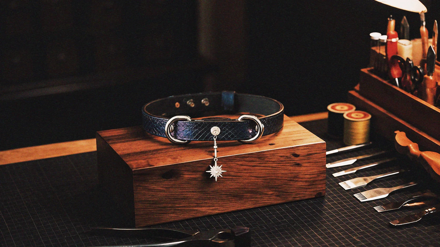 Python Star Pendant Leather Collar warm tabletop studio scene with wooden box, purple and black python-textured leather, and star pendant.