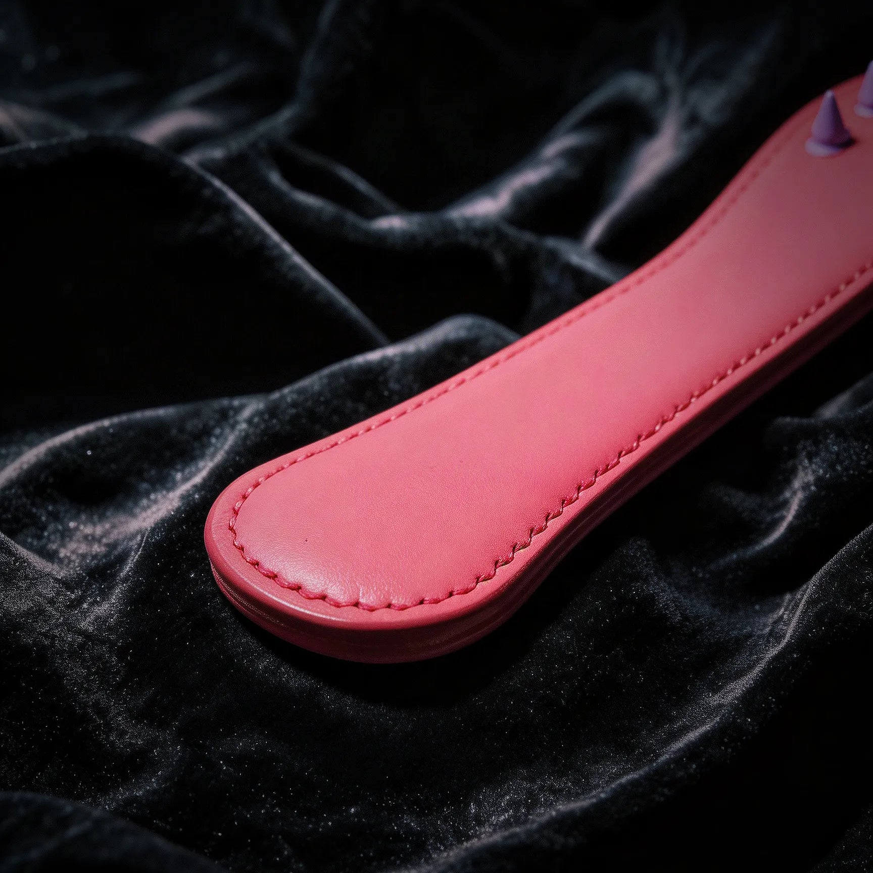 Rose Thorn studded leather paddle angle view with elongated silhouette and broad handle grip
