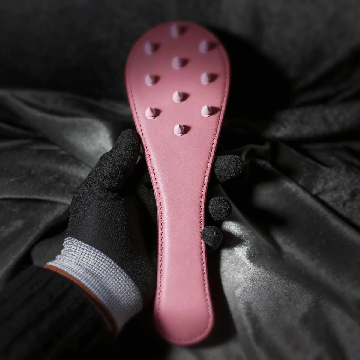 Rose Thorn leather paddle detail view with raised stud pattern and smooth blush leather finish