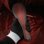 Scarlet Scale Textured Leather Paddle hand-held studio detail showing scale texture and raised textured face.
