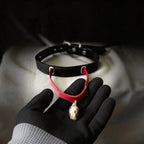 Serpent Mark Pendant Leather Collar hand-held red satin scene with black and crimson leather and silver hardware.