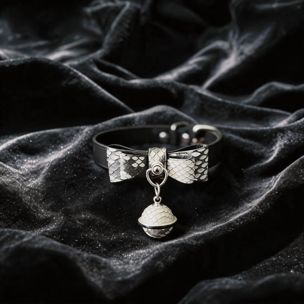Serpentine Grace Bow Bell Leather Collar black and white python-textured leather collar on black satin with bow and bell charm.