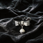 Serpentine Grace Bow Bell Leather Collar black and white python-textured leather collar on black satin with bow and bell charm.