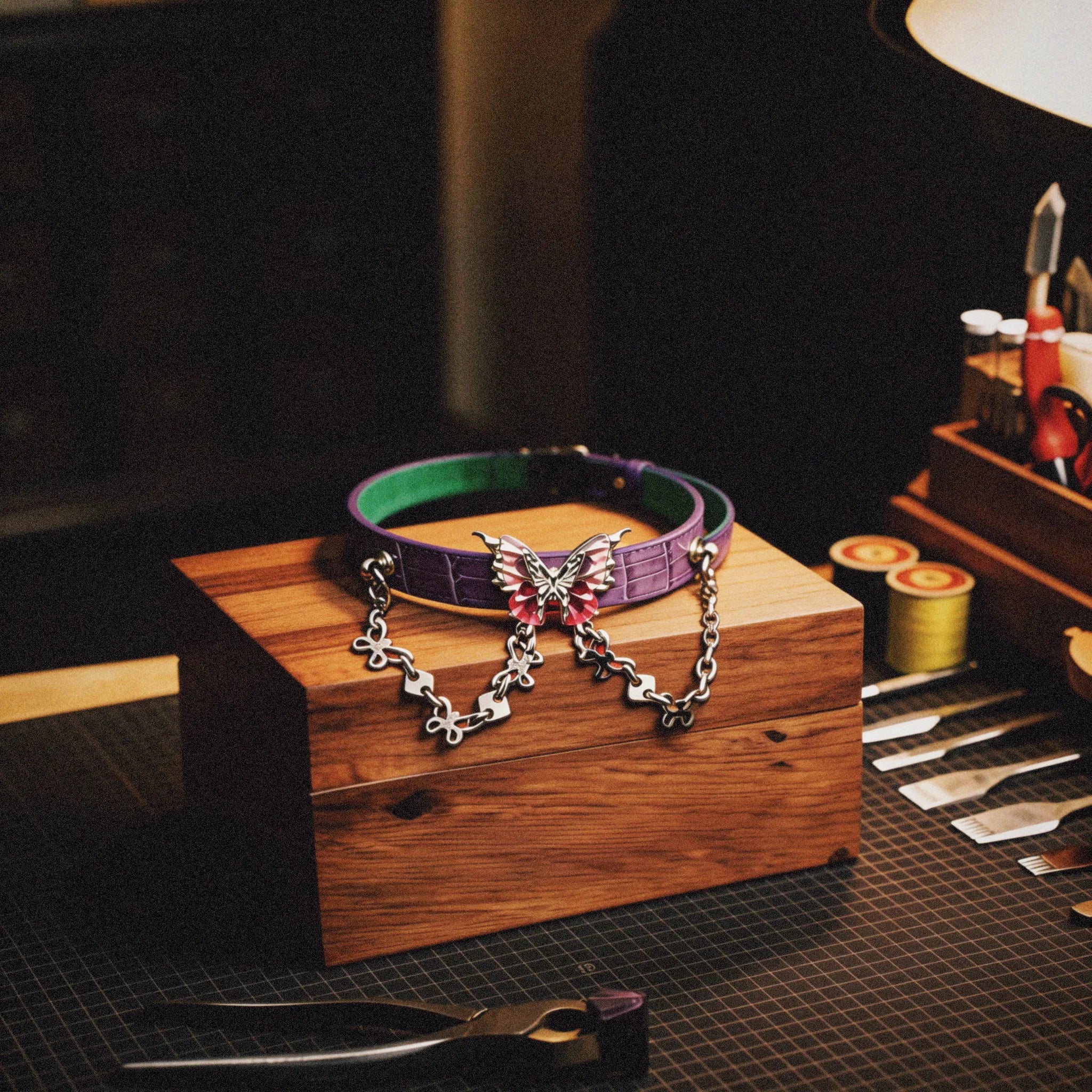 Violet Flutter butterfly chain leather collar studio display on a wooden stand with embossed lavender leather, mint inner accent